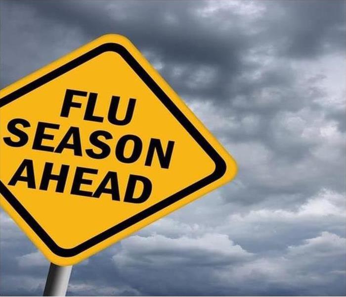 a yellow yield sign with a words reading out flu season ahead
